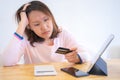 Confused portraitÃÂ young woman holding credit cards having problem online payment with credit card making rejected unsecure online Royalty Free Stock Photo